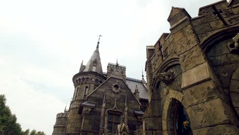 stone-sculptures-on-facade-of-fortress,-stained-windows,-gothic-style,-camera-is-moving