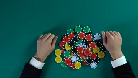 Hands-of-businessman-taking-all-chips-in-casino,-monopoly-on-market,-top-view