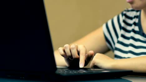 SLOW-MOTION:-Female-Hand-Using-Touchpad-on-the-Laptop-Sitting-at-the-Table-at-Home