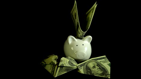 Piggy-bank-and-dollar-bills-turn-on-a-black-background