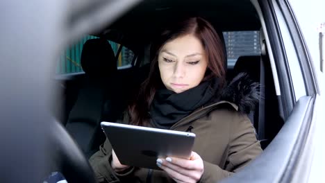 Joven-mujer-navegación-Tablet-mientras-está-sentado-en-el-coche