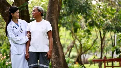 Young-female-doctor-talking-to-senior-patient-in-hospital-garden