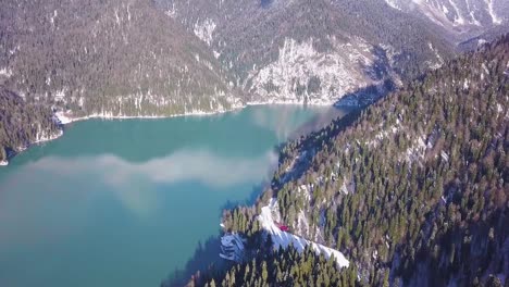 Panoramische-Ansicht-der-schönen-weißen-Wunderland-Winterlandschaft-mit-schneebedeckten-Berggipfeln.-Clip.-Kristallklaren-Bergsee-an-einem-kalten,-sonnigen-Tag-mit-blauem-Himmel-und-Wolken