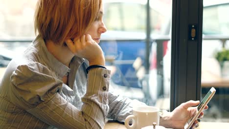 Frau-scrollen-das-Smartphone-social-Media-allein-sitzen-in-einem-Café-zu-überprüfen