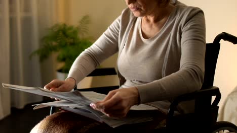 Mujer-inteligente-en-silla-de-ruedas-de-lectura-diario,-vejez-ocio,-tiempo-libre