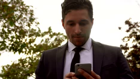 Man-in-a-suit-using-application-on-a-smartphone-next-to-the-Eiffel-Tower