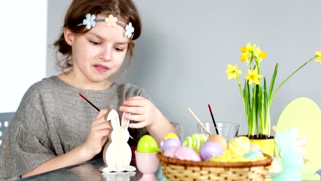 La-niña-pinta-el-conejito-de-Pascua-con-gouache.-Preparación-mira-concentrada-y-serio.-Creatividad-infantil,-desarrollo-de-habilidades-de-los-niños.-Terapia-del-arte