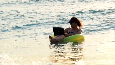 Eine-Mädchen-ist-mit-einem-Laptop-schwimmen.