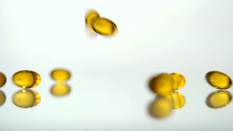 Medical-pills-scatter-on-a-white-background.Yellow-pills.-Slow-motion.-Pills-background