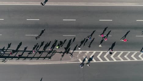 4K-Luftbild-Drohne-Fooage.-Marathon-laufen-auf-der-Straße.-Gruppe-der-Unterstützung.-Ansicht-von-oben