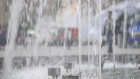 Der-Brunnen-in-der-Stadt-ist-close-up.-Wasserstrahlen-verlangsamt.-Stadtstraße-Sommer