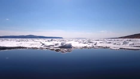 eine-Drohne-fliegen-über-einen-gefrorenen-Fluss,-Wasser-und-Eis-auf-einem-gefrorenen-Fluss