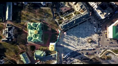 A-bird's-eye-view,-panoramic-video-from-the-drone-in-FullHD-to-the-Saint-Sophia's-Cathedral,-Sofiyivska-Square,-Kiev,-Ukraine.-People-on-the-square-on-Easter-days.-Dolly-out-motion.