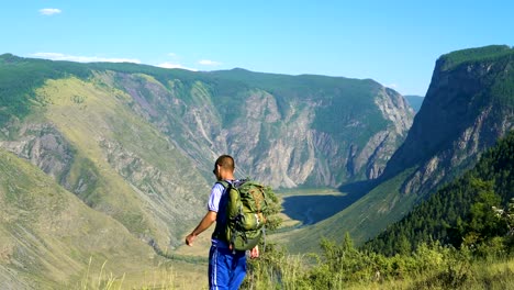 Un-turista-con-una-mochila-en-la-montaña.