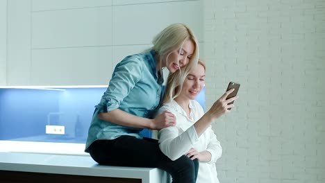 Zwei-Frauen,-die-Fotos-auf-dem-Smartphone-ansehen