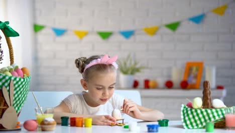 Adorable-niña-decorando-huevos-de-Pascua-con-pintura-de-colores,-niño-talento