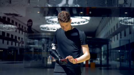 Young-man-is-using-his-smartphone-with-an-artificial-hand.-Man-of-future-concept.