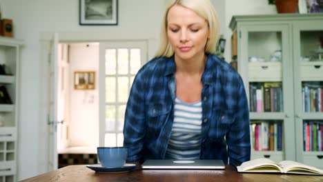 Attraktive-blonde-Frau-sitzt-am-Tisch-mit-Laptop