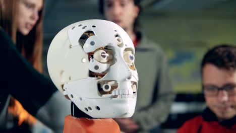 Detailed-view-of-a-robot's-face-with-specialists-talking-in-the-background