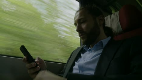 Portrait-of-young-serious-business-traveler-using-his-smartphone-working-online-concept-of-business-travel-and-modern-technology-communication