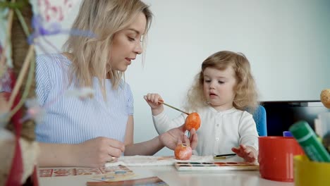 Mother-and-her-little-daughter-painting-Easter-eggs