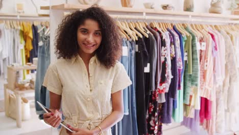 Mujer-propietaria-de-la-tienda-de-ropa-independiente-con-tableta-digital-sonriendo-a-cámara-Shot-en-slow-motion