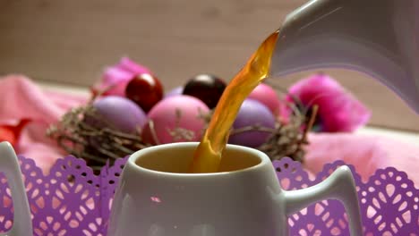 Colored-pink-Easter-egg-lies.-Tea-poured-in-the-cup