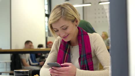 technologie.-Lächelnde-Frau-nutzt-Handy-im-Cafe-Indoors