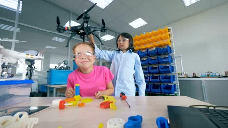 Two-school-children-fixing-drone-model-in-modern-technology-school-class.-4K.