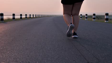 Overweight-Asian-women-jogging-in-the-street-in-the-early-morning-sunlight.-concept-of-losing-weight-with-exercise-for-health.-Slow-motion,-Bottom-view