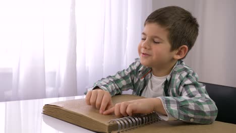 aprender-para-el-niño-ciego,-enfermo-niño-leyendo-Braille-libro-con-caracteres-fuente-para-discapacitados-visuales-sentados-en-la-mesa