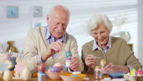 Pareja-sonriendo-y-riendo-al-pintar-huevos