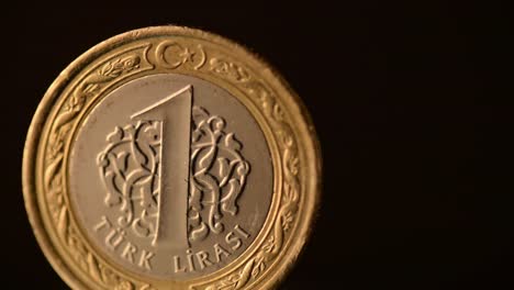 One-Turkish-Lira-Coin-is-rotating-on-a-black-background,-close-up-footage.