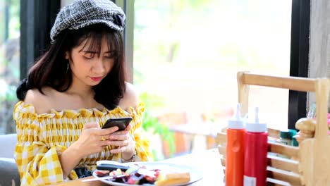 Asiatische-junge-Frau-fotografiert-Frühstück-mit-Smartphone-Social-Media