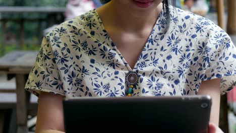 Junge-asiatische-Frau-mit-Tablet-im-Café.-Technologie-Social-Media.