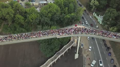 Eine-Menschenmenge-auf-einer-Fußgängerbrücke-ist-am-Frühlingsabend-zu-sehen.-Luftaufnahme.-Eine-neue-Fahrrad-Fußgängerbrücke-im-Zentrum-der-Hauptstadt-der-Ukraine,-der-Stadt-Kiew.-Ausflüge-und-Spaziergänge-für-Touristen