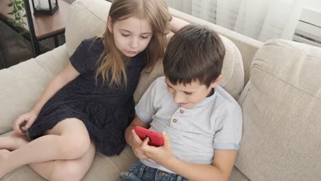 Children-with-mobile-phone-on-sofa