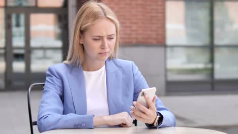 Joven-empresaria-molesta-por-pérdida-durante-el-uso-de-Smartphone