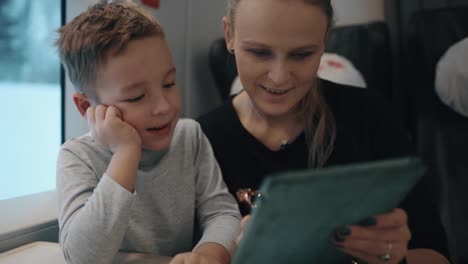 Mamá-e-hijo-jugando-en-la-almohadilla-en-el-tren