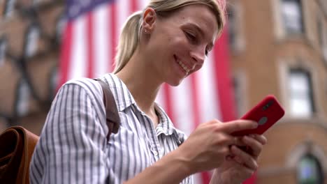 Kaukasische-lächelnde-Frau-tippt-Text-über-mobile-Tastatur-für-das-Senden-von-SMS-Antwort-an-soziale-Freundin-aus-dem-Netzwerk