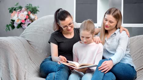 Zwei-glückliche-junge-Mutter-lesen-Buch-mit-Teenager-Tochter-mit-positiven-Emotionen