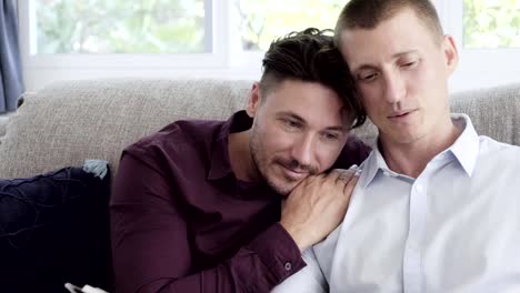 Gay-couple-relaxing-on-couch.-Lean-on-shoulder.