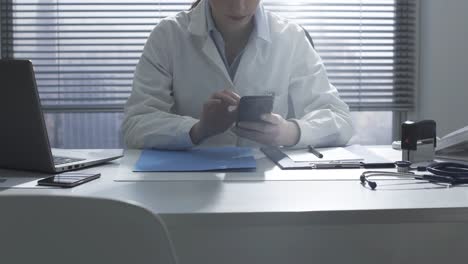 Doctor-working-in-the-office-and-using-a-smartphone