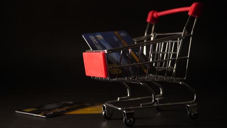 Credit-card-falling-down-on-mini-shopping-cart