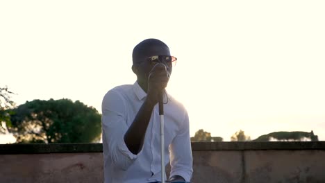 Visually-impared-black-man-sitting-in-the-park-at-sunset.Blindness,-indipendance