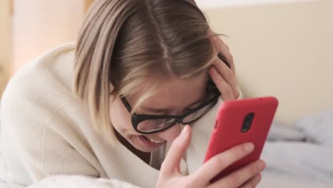 Mujer-sorprendida-usando-el-teléfono-móvil-en-la-cama