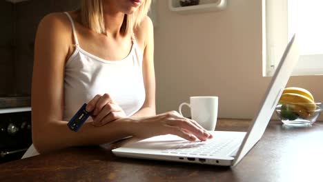 Young-woman-holding-pregnancy-test-and-using-and-laptop-at-home