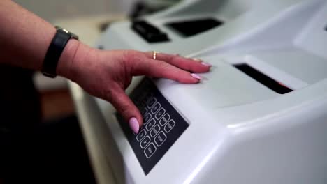 Female-lab-technician-sets-up-a-laboratory-machine-for-blood-analysis.-Modern-medical-technology.