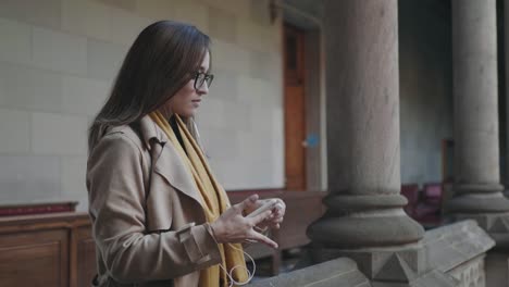 Estudiante-poniéndose-auriculares-en-el-pasillo.-Empresaria-escuchando-música-en-auriculares