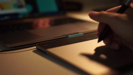 Close-up-view-of-graphic-designer-hand-using-graphics-tablet-working-over-night